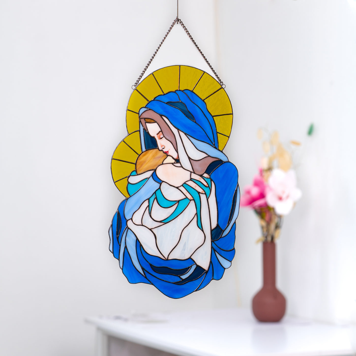 Stained glass window panel of Virgin Mary with Jesus Christ coloured like Ukrainian flag