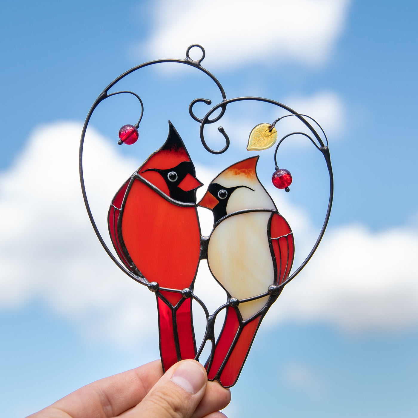 Stained glass cardinals in love sitting on the branch with leaves and berries suncatcher
