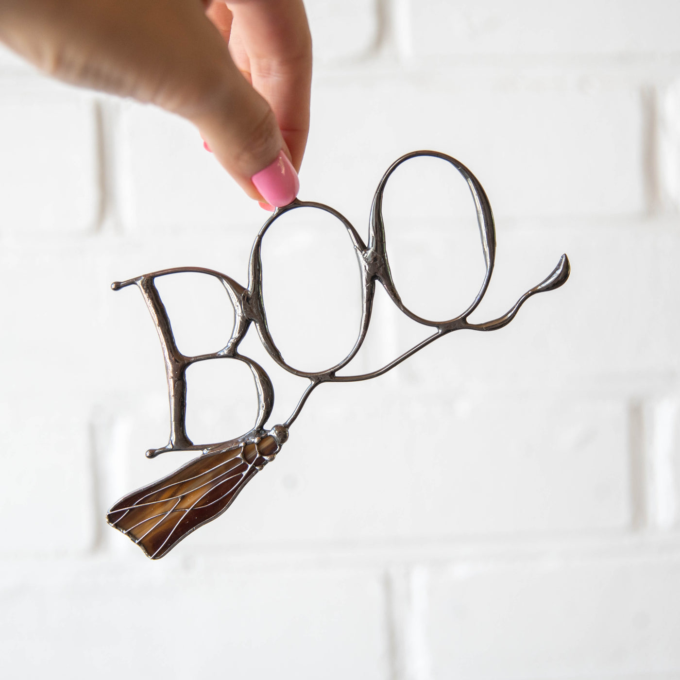 Lettering boo on witch's broom suncatcher of stained glass