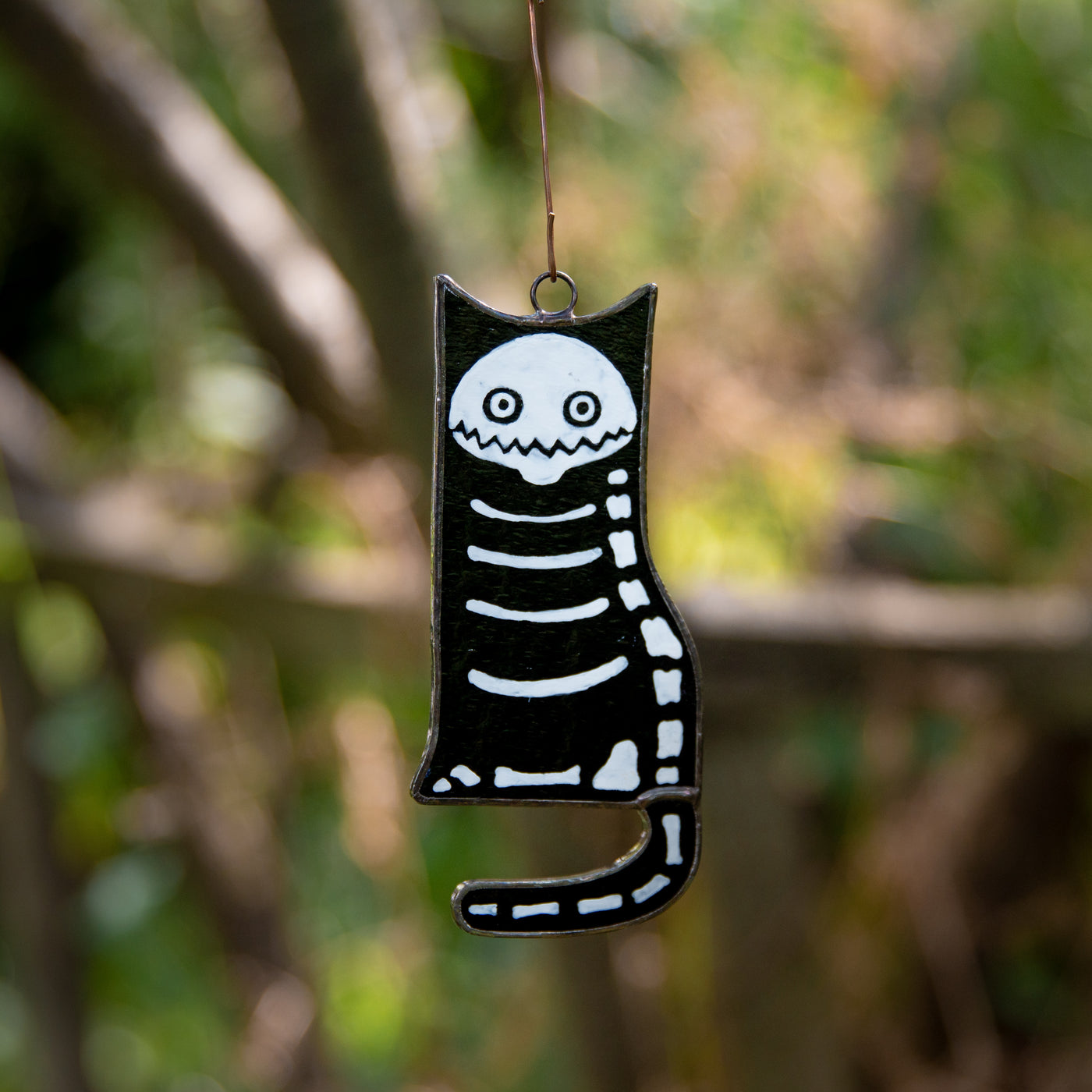 Stained glass suncatcher of a cat skeleton for ghastly Halloween decor