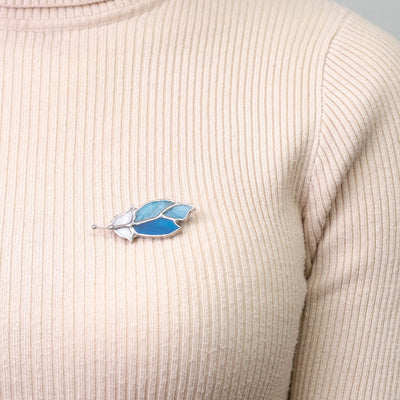 Light-blue stained glass feather pin