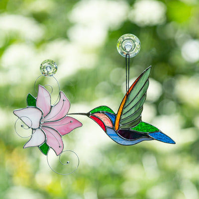 Stained glass lily and hummingbird flying to it suncatchers