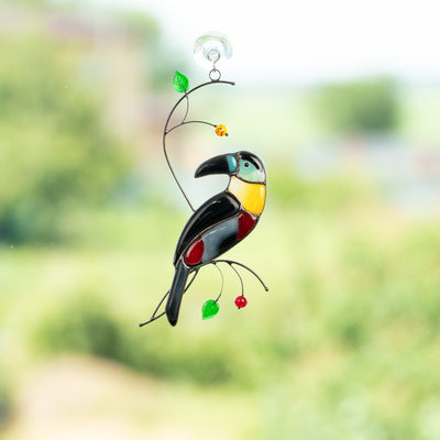 Stained glass toucan with bluish head and yellow neck on the branch  suncatcher