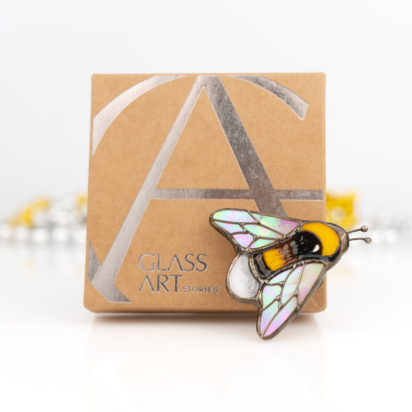 Stained glass bubble bee pin and a brand box