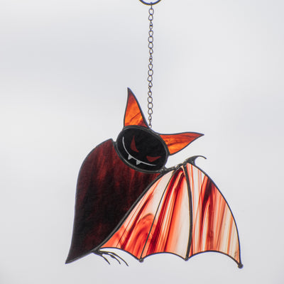 Stained glass brown bat with baroque wings and red eyes window hanging