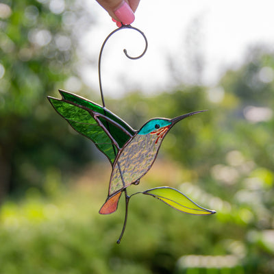 Stained glass sun catcher of flying green hummingbird