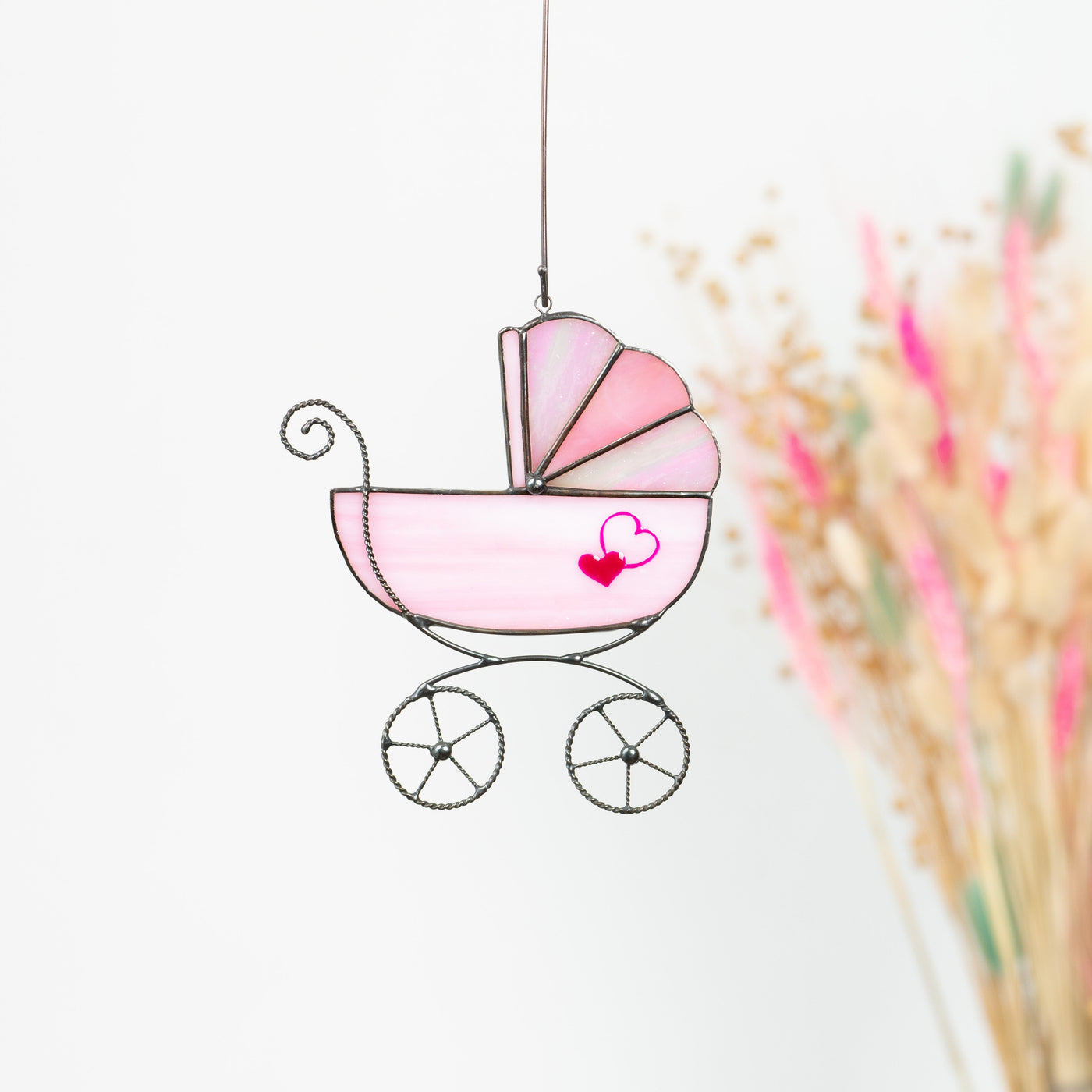 Pink baby stroller window hanging of stained glass