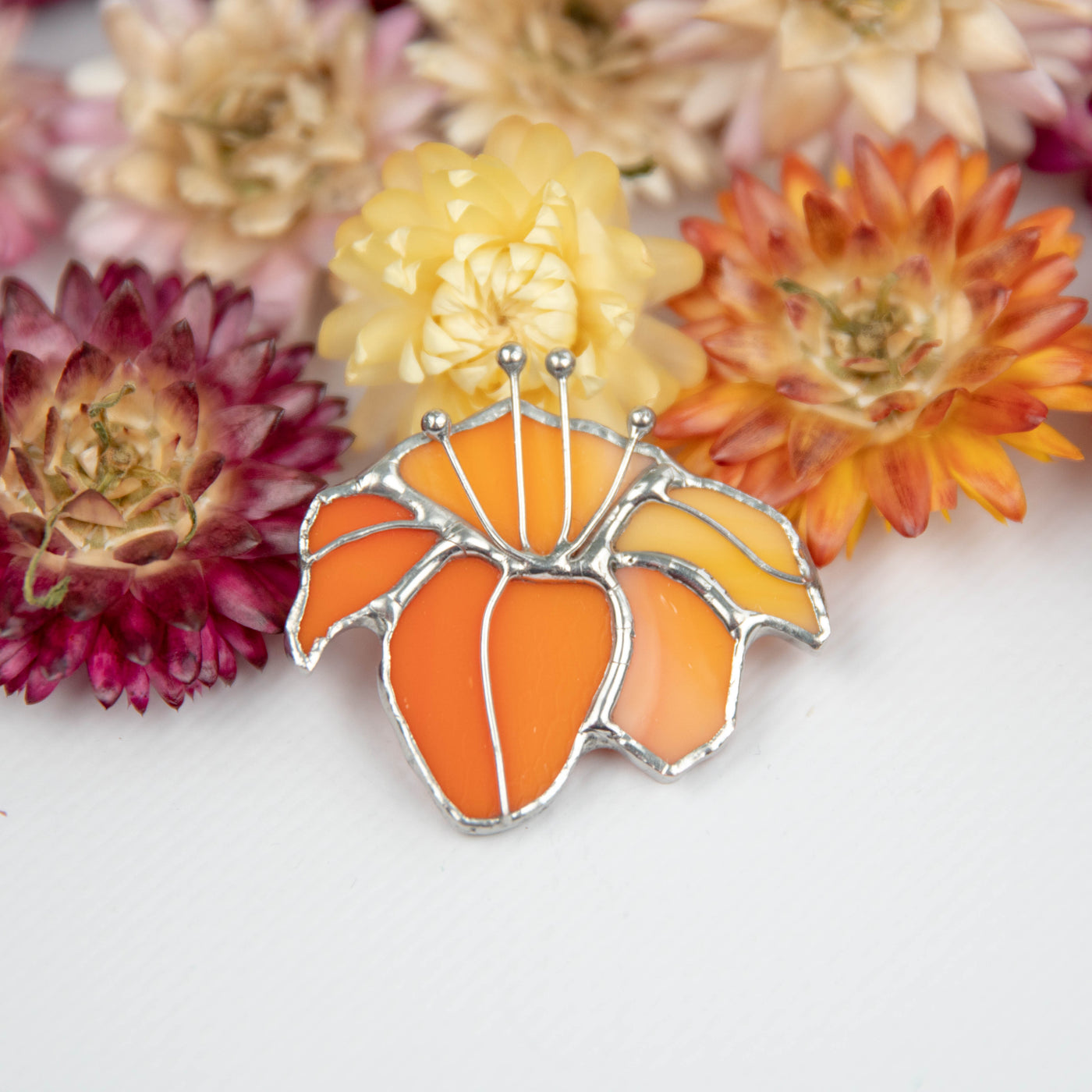 Zoomed stained glass lily pin of orange color