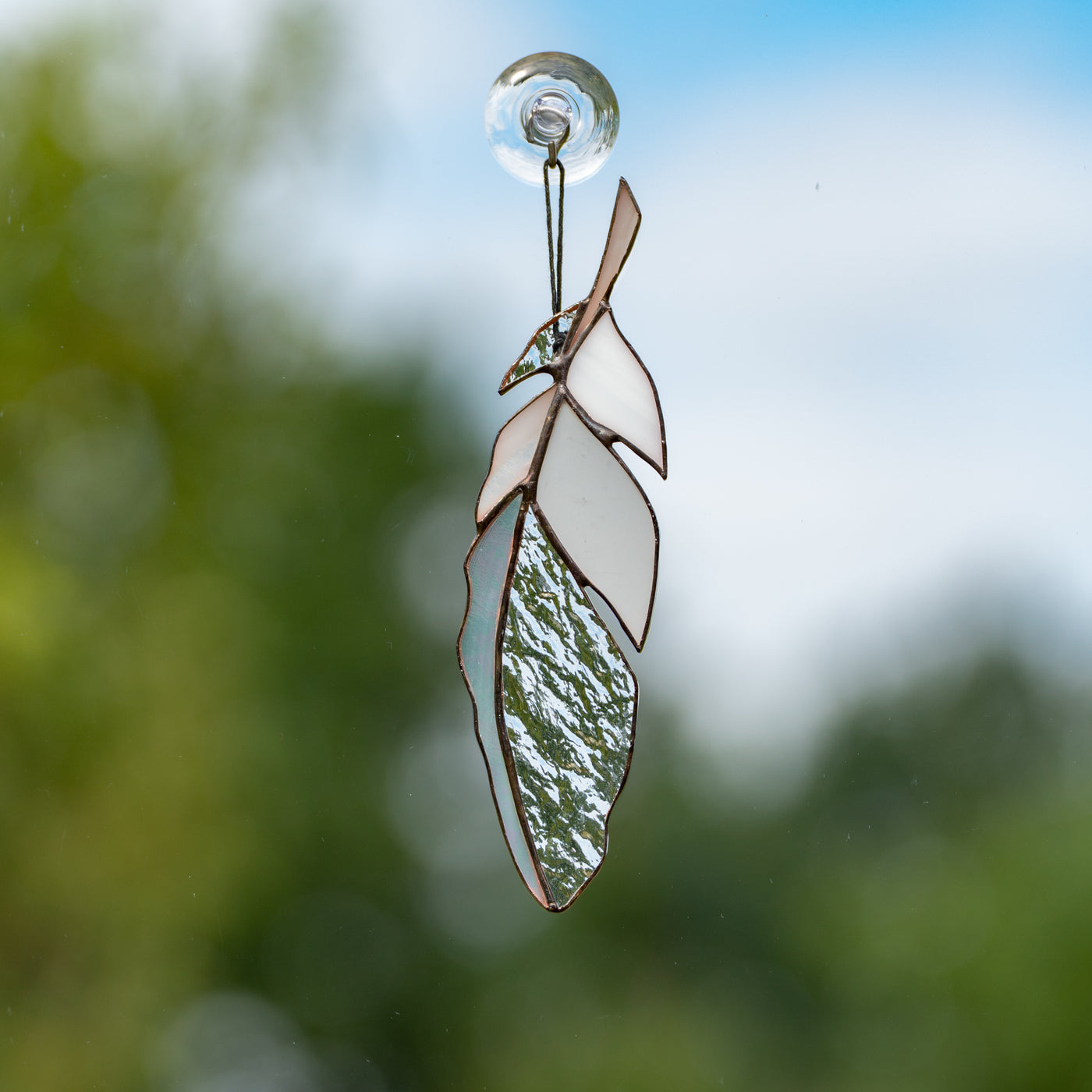 Suncatcher of a stained glass white and clear feather
