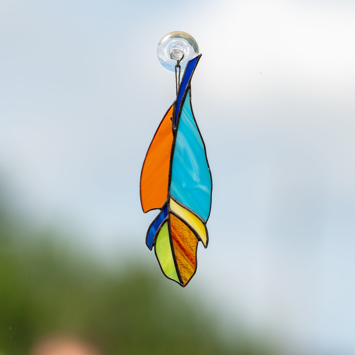 Stained glass feather suncatcher of blue and orange colours 