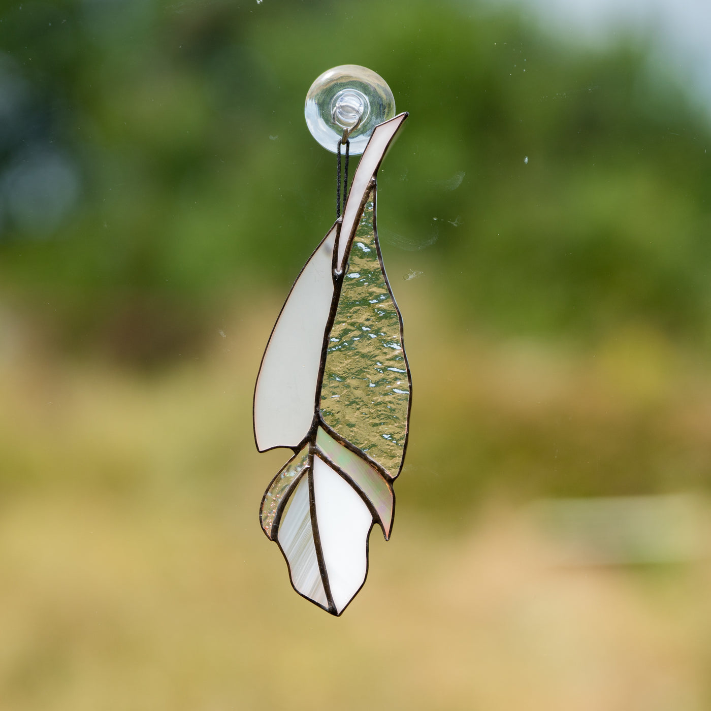 Suncatcher of a stained glass clear with iridescent parts  feather