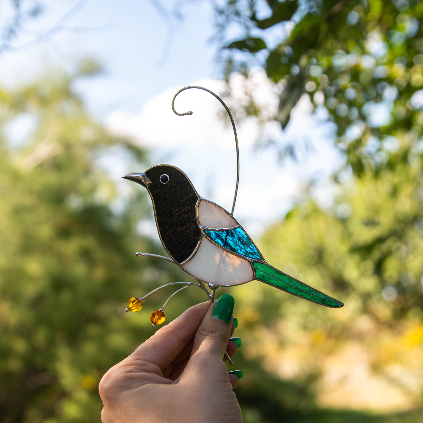 Magpie sitting on the branch and looking left suncatcher of stained glass