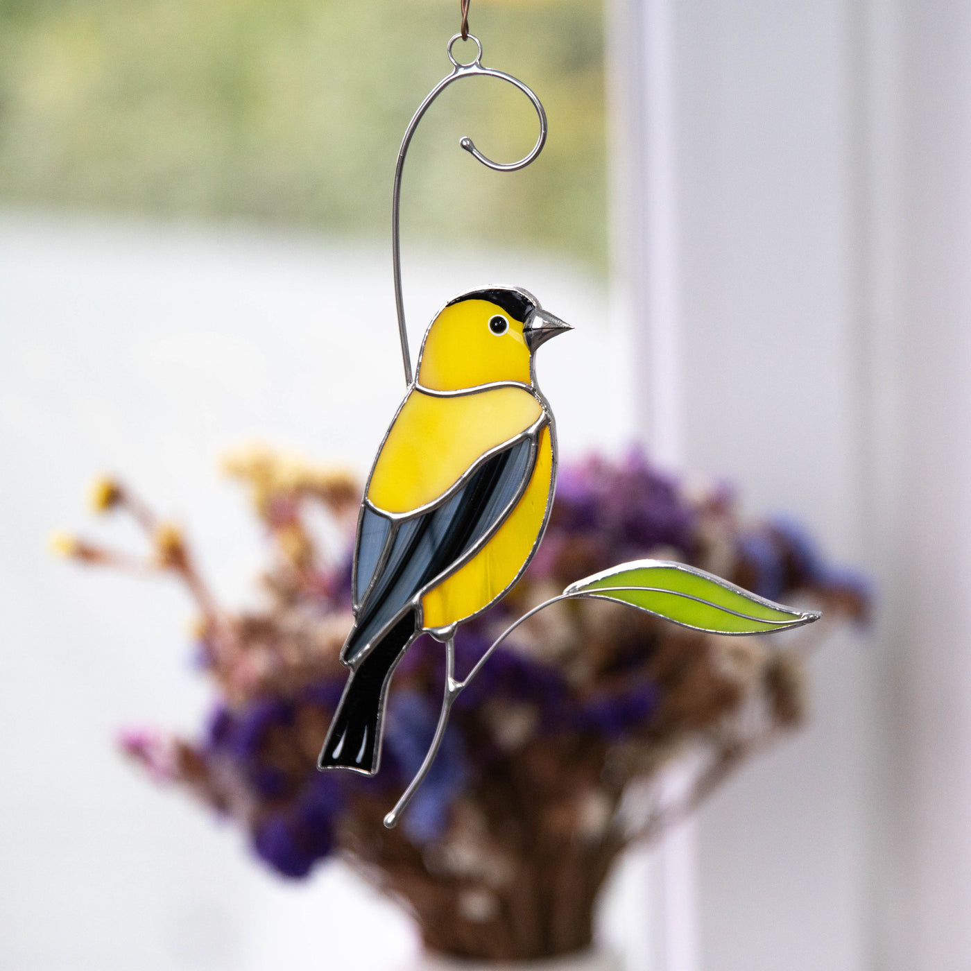 Goldfinch looking right on the branch suncatcher of stained glass
