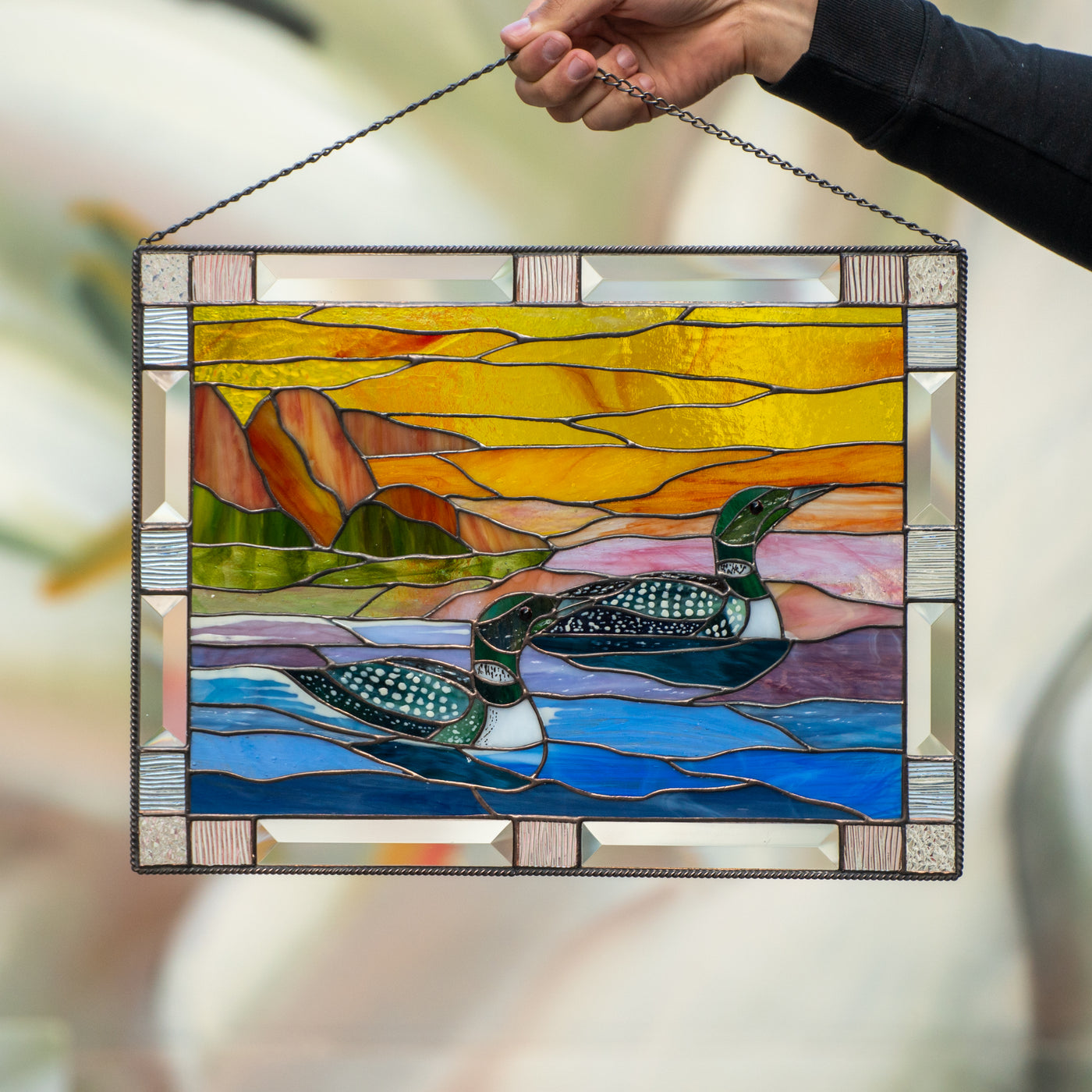 Stained glass panel depicting two ducks and the sunset