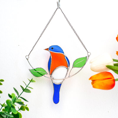 Stained glass bluebird sitting on the chain with two green leaves suncatcher 