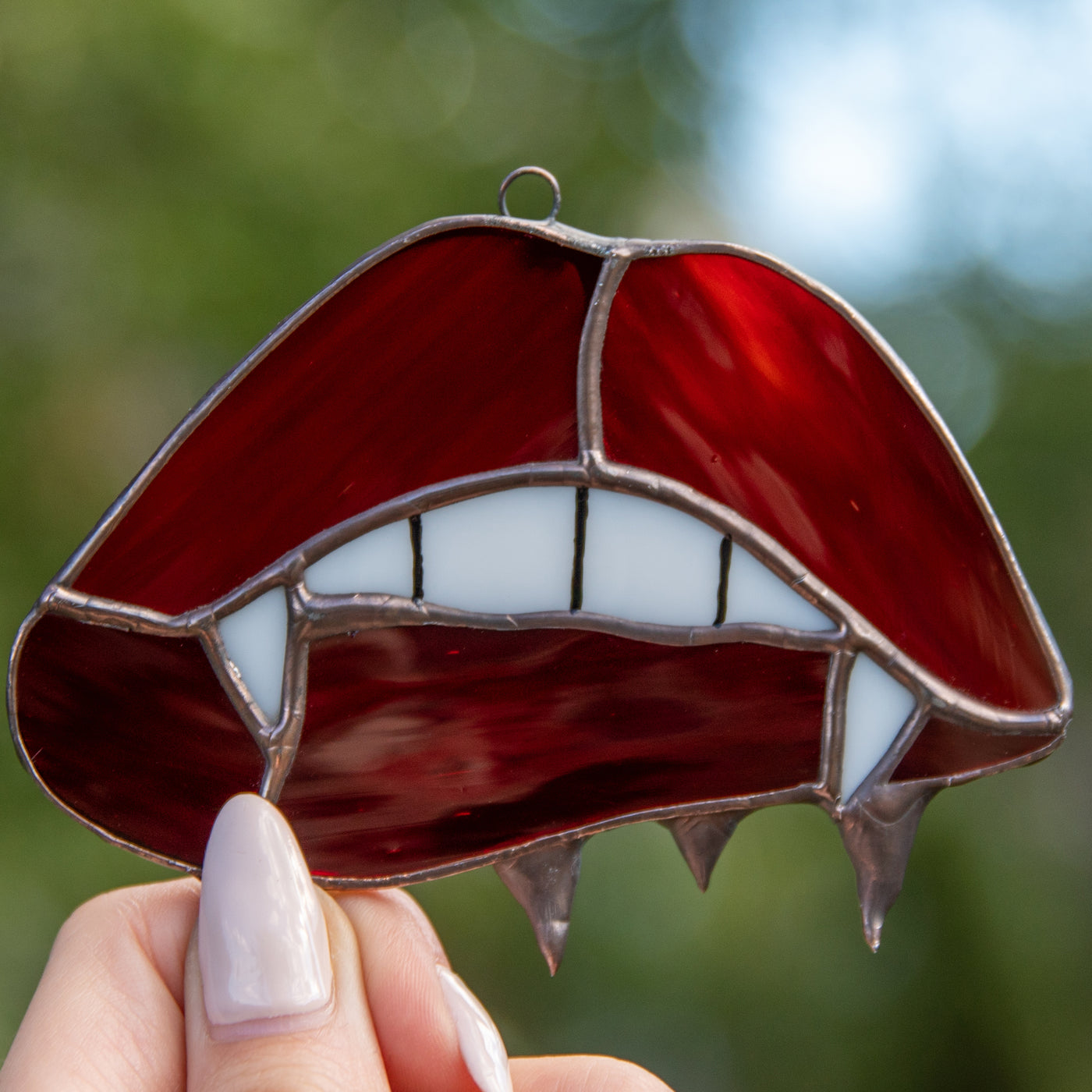 Zoomed stained glass vampire lips and teeth window hanging for Halloween decor