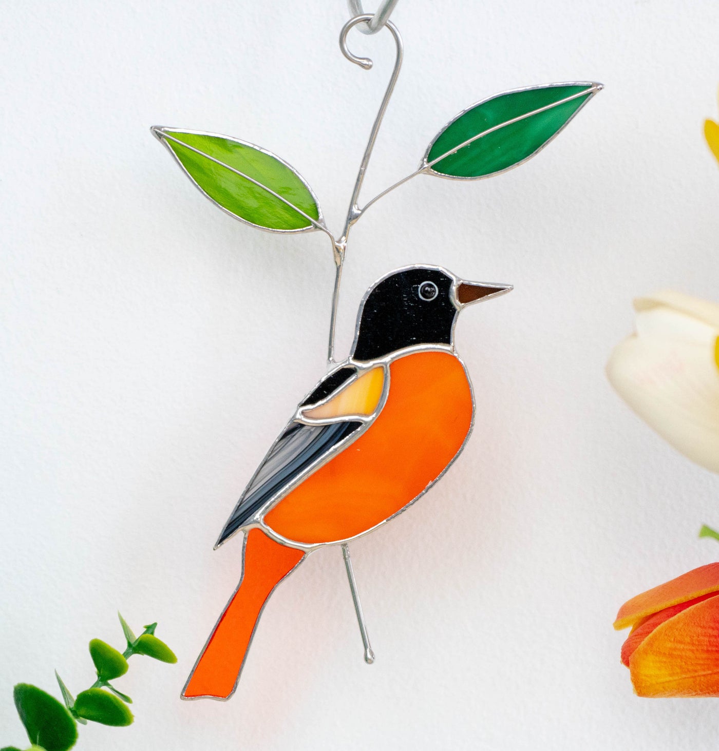 Stained glass Baltimore Oriole on the branch with leaves suncatcher 