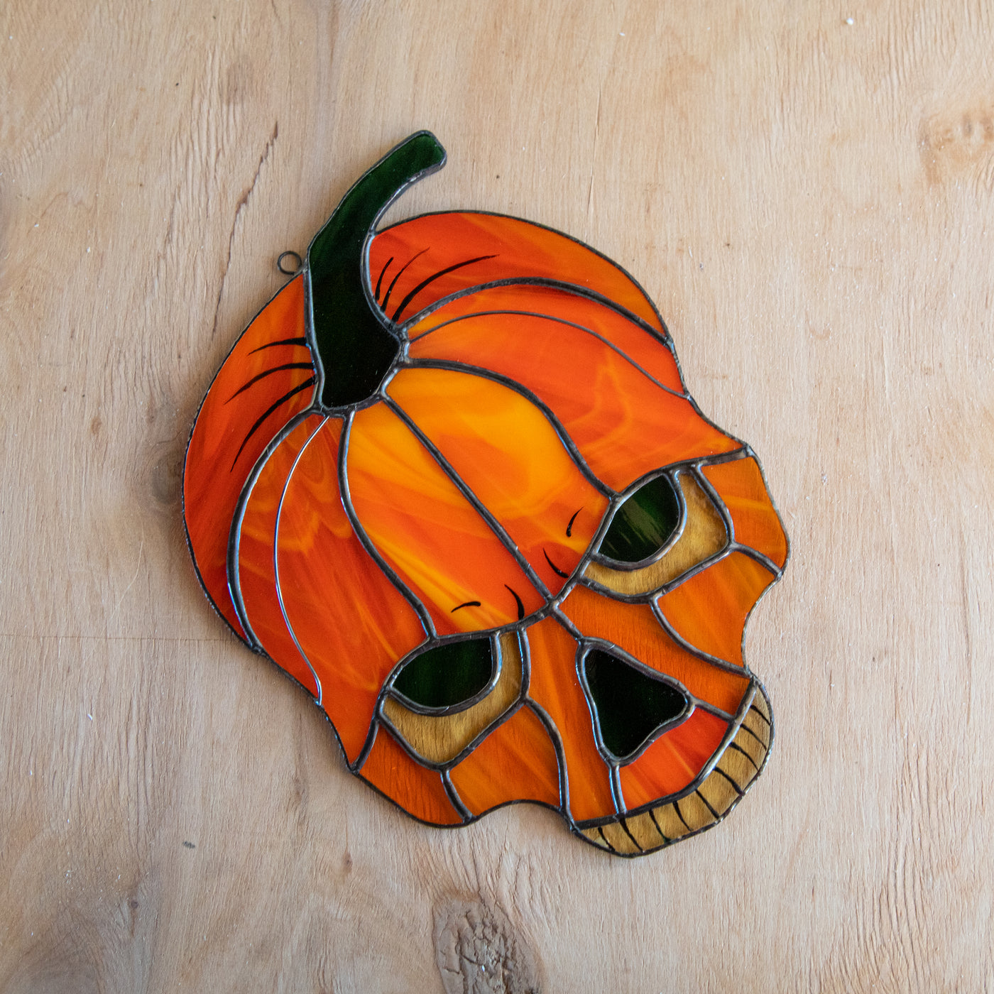 Stained glass pumpkin skull window hanging for ghastly Halloween decor