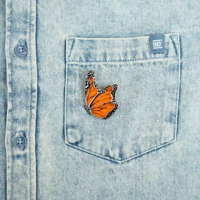 Side-view stained glass monarch butterfly pin on a jeans jacket