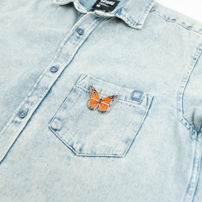 Stained glass top-view monarch butterfly pin on a jeans jacket