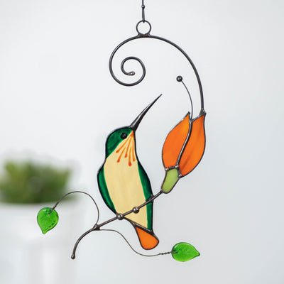 Zoomed stained glass orange and green hummingbird suncatcher