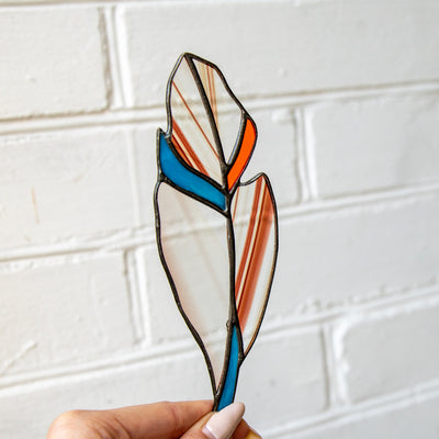 Stained glass window hanging of a clear with bardic blotchiness feather