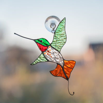 Stained glass hummingbird with green wings and orange tail suncatcher