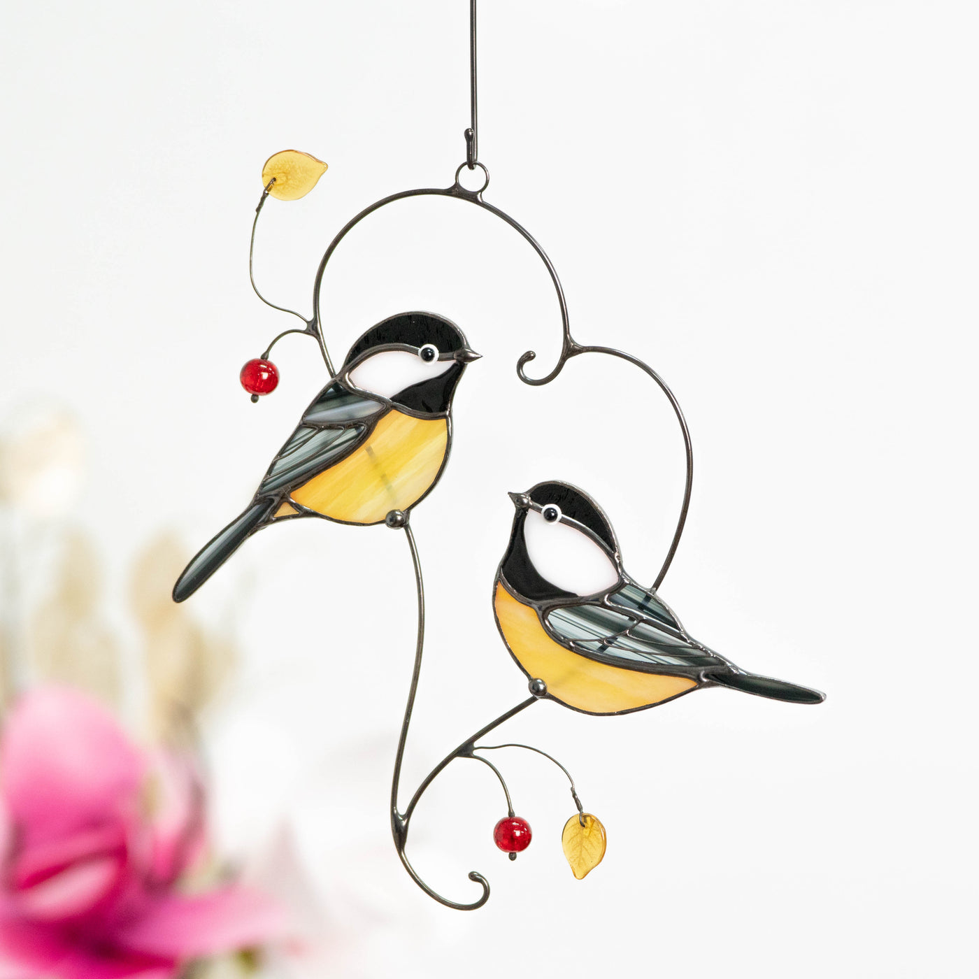 Stained glass window hanging of chickadees sitting on the branch in the shape of heart 