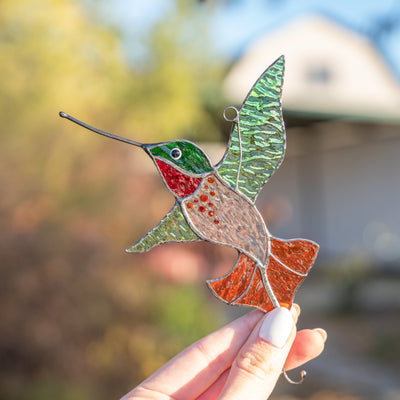 Hummingbird with green wings and orange tail stained glass suncatcher