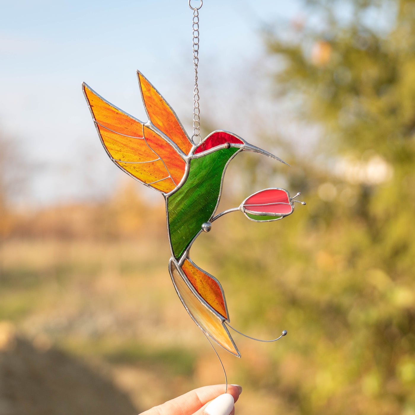 Stained glass green hummingbird with orange wings and tail suncatcher 