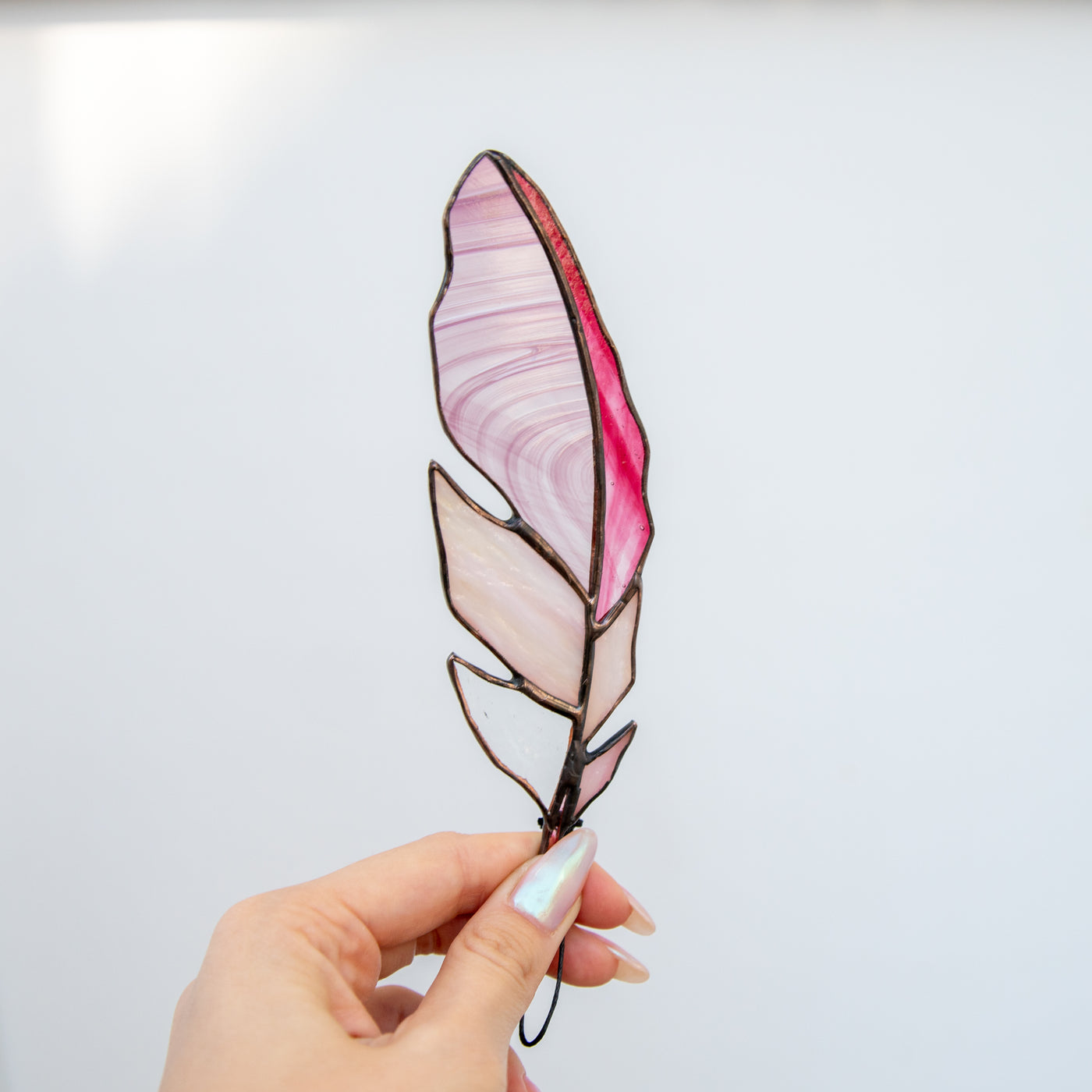 Saturated pink with pink blotchiness feather suncatcher of stained glass
