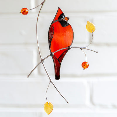 Stained glass suncatcher of a redbird on the branch 