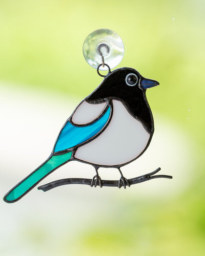 small fat magpie sitting on a branch stained glass suncatcher