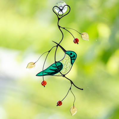 Stained glass green female hummingbird sitting on the branch with leaves and berries suncatcher