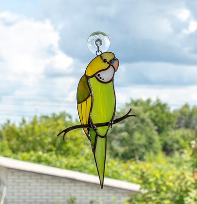Green stained glass budgie on the branch
