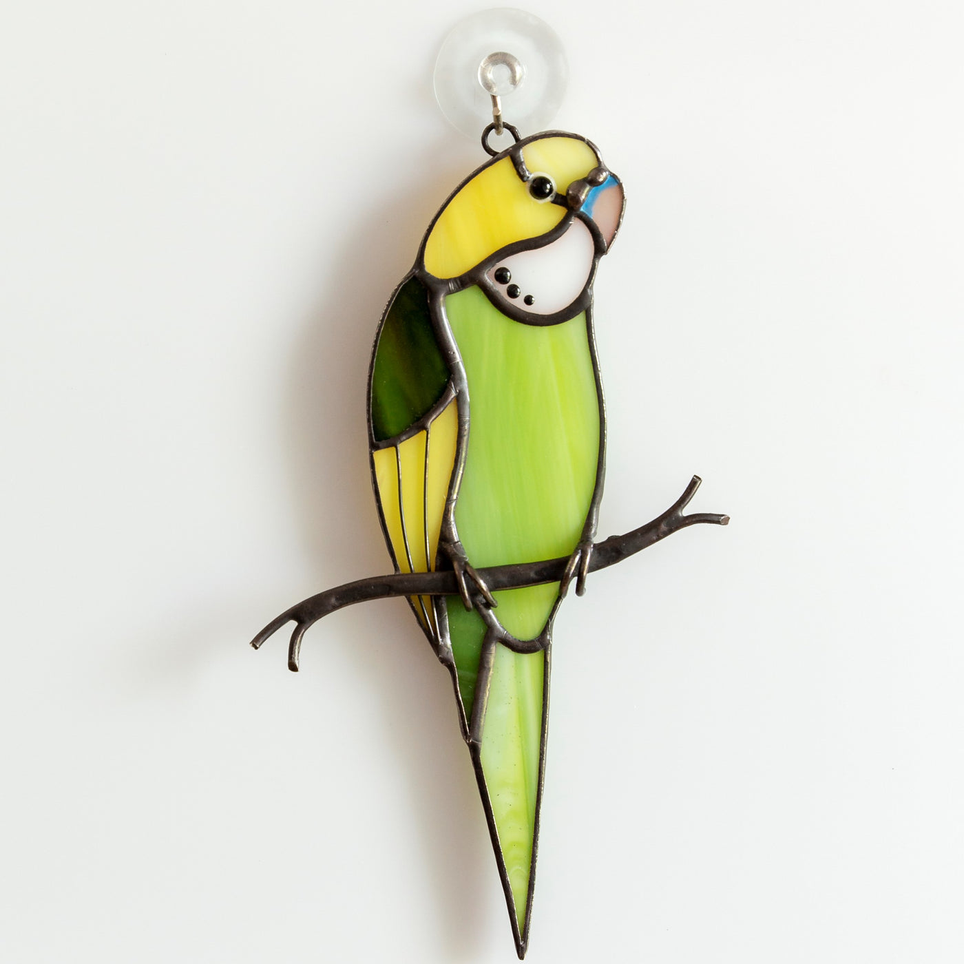 Sitting on the branch green budgie of stained glass 