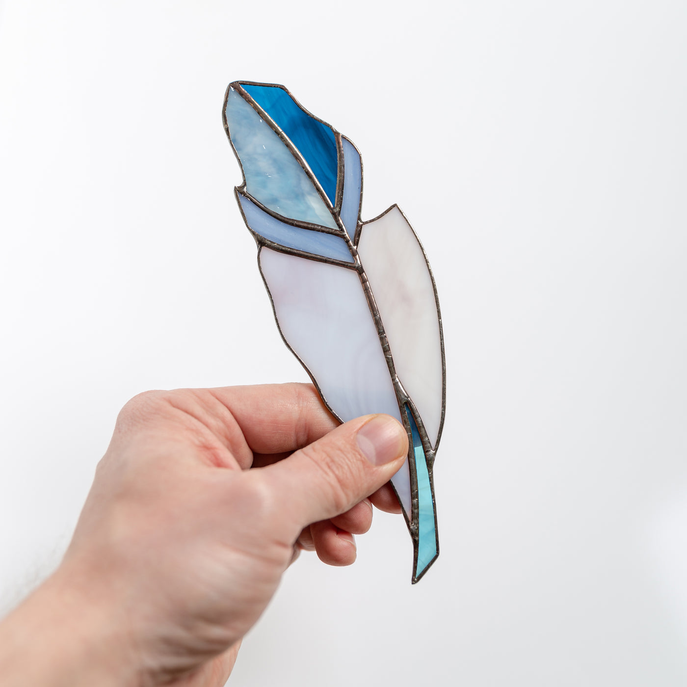 Stained glass feather suncatcher of blue colour and its shades