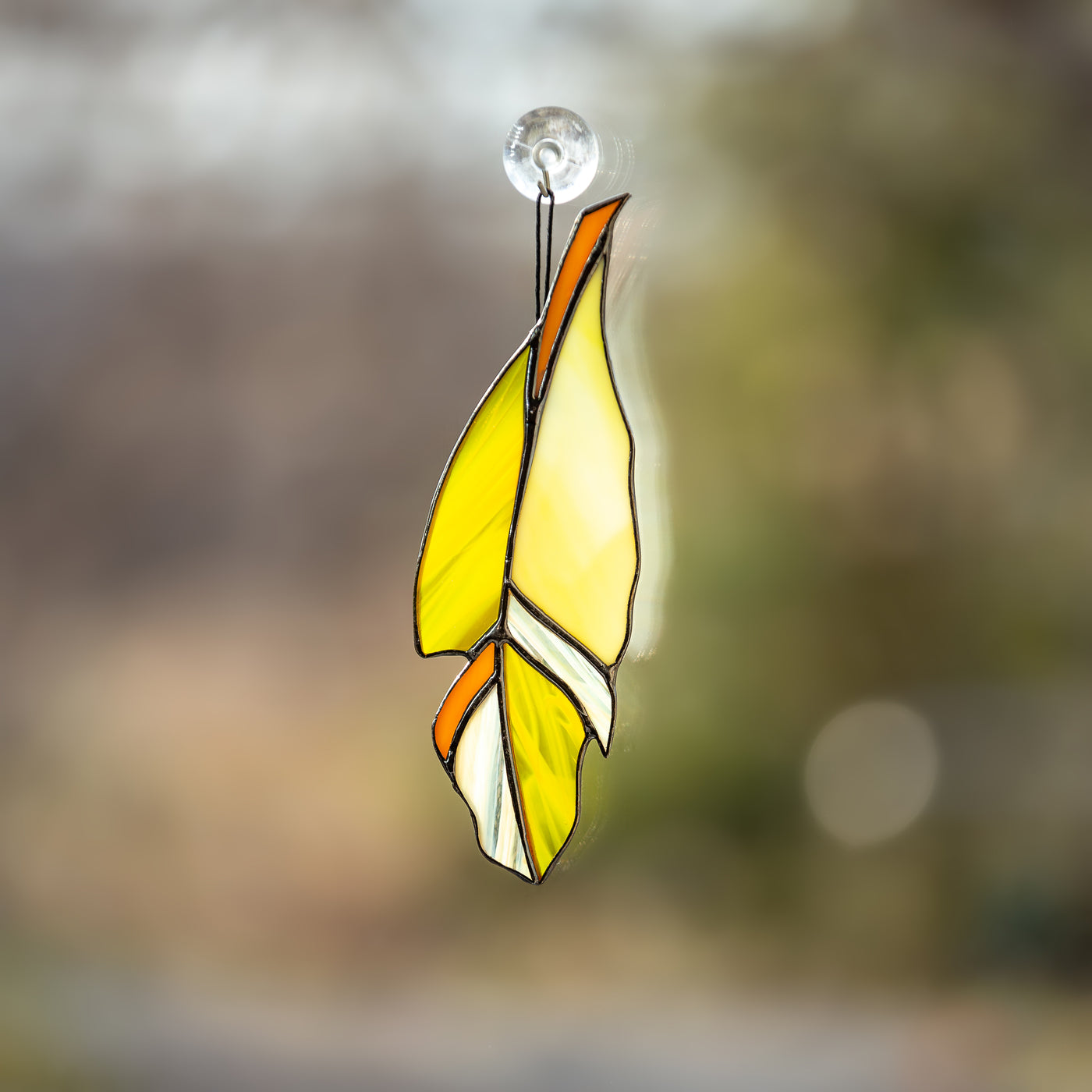 Bright yellow stained glass feather window hanging 