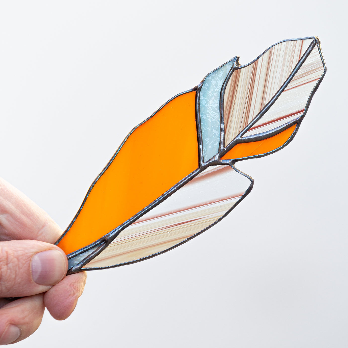 Zoomed orange feather suncatcher of stained glass