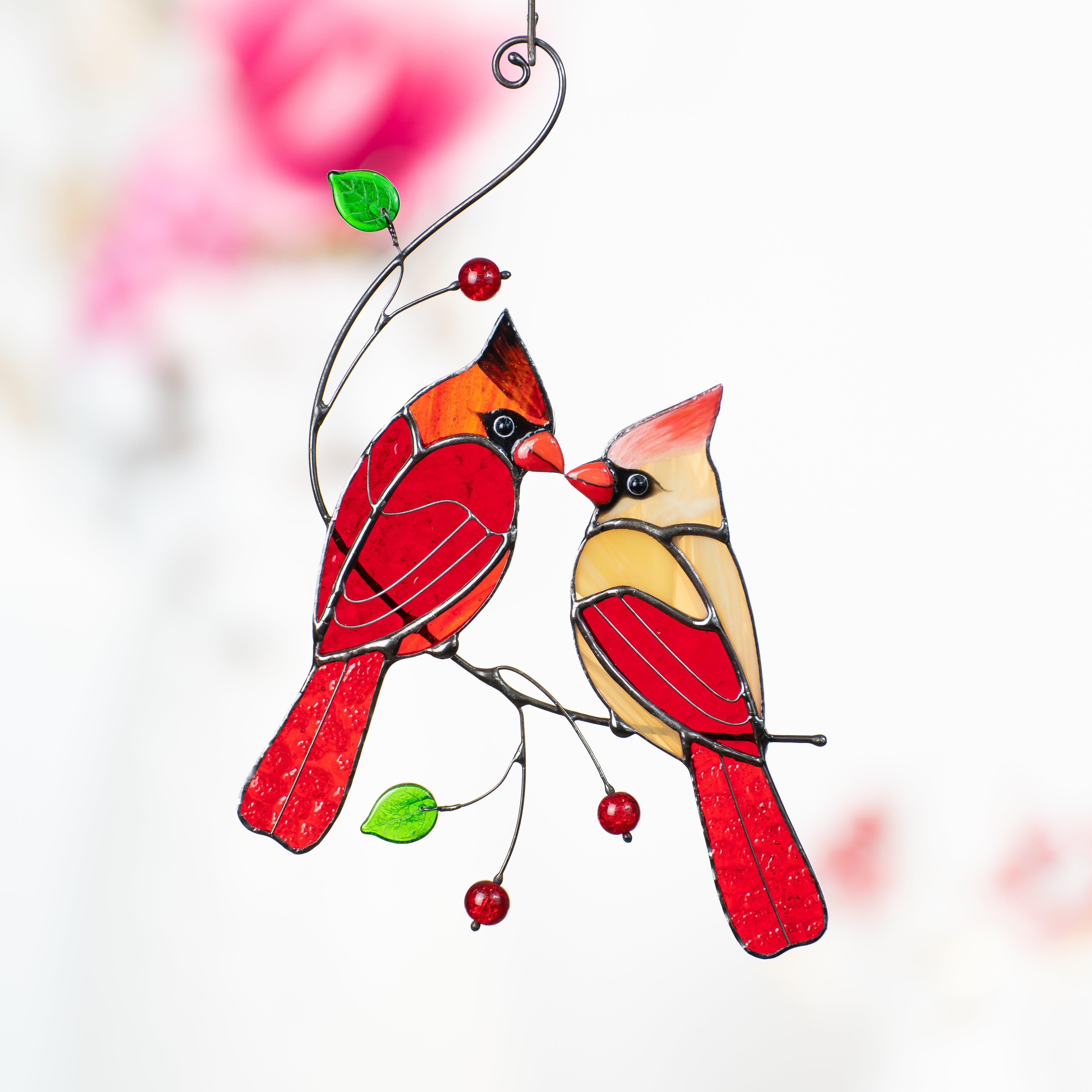 Stained glass suncatcher of kissing cardinals on the branch with leaves and beads