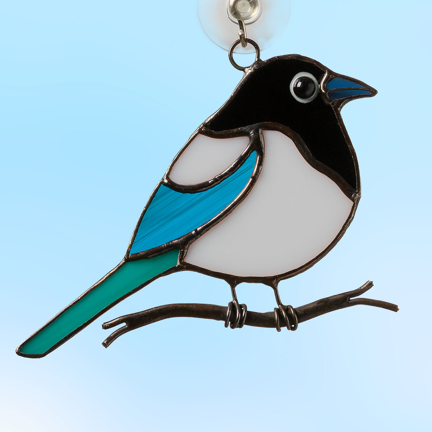 small fat magpie sitting on a branch stained glass suncatcher  Edit alt text