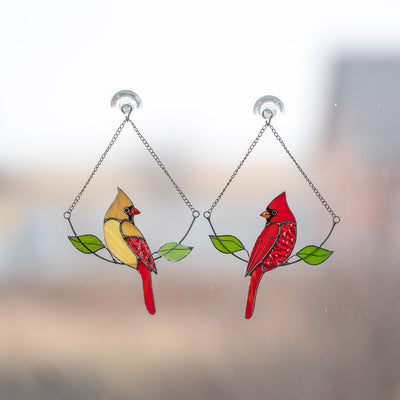 Set of stained glass female and male cardinals sitting on the chains suncatchers