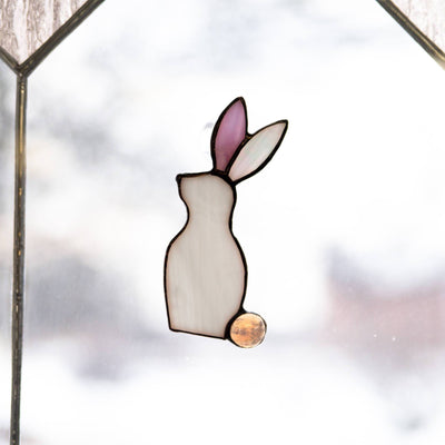 Suncatcher of a stained glass white bunny with a pink ear 