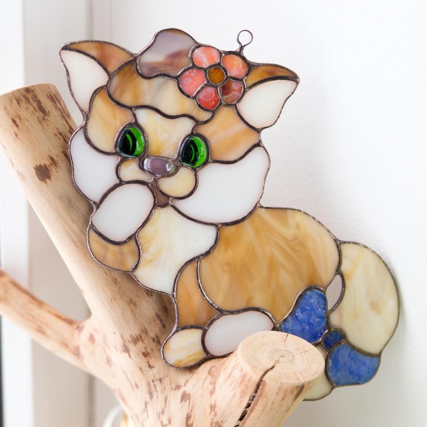 Stained glass kitty with the bow window hanging on the decorative tree 