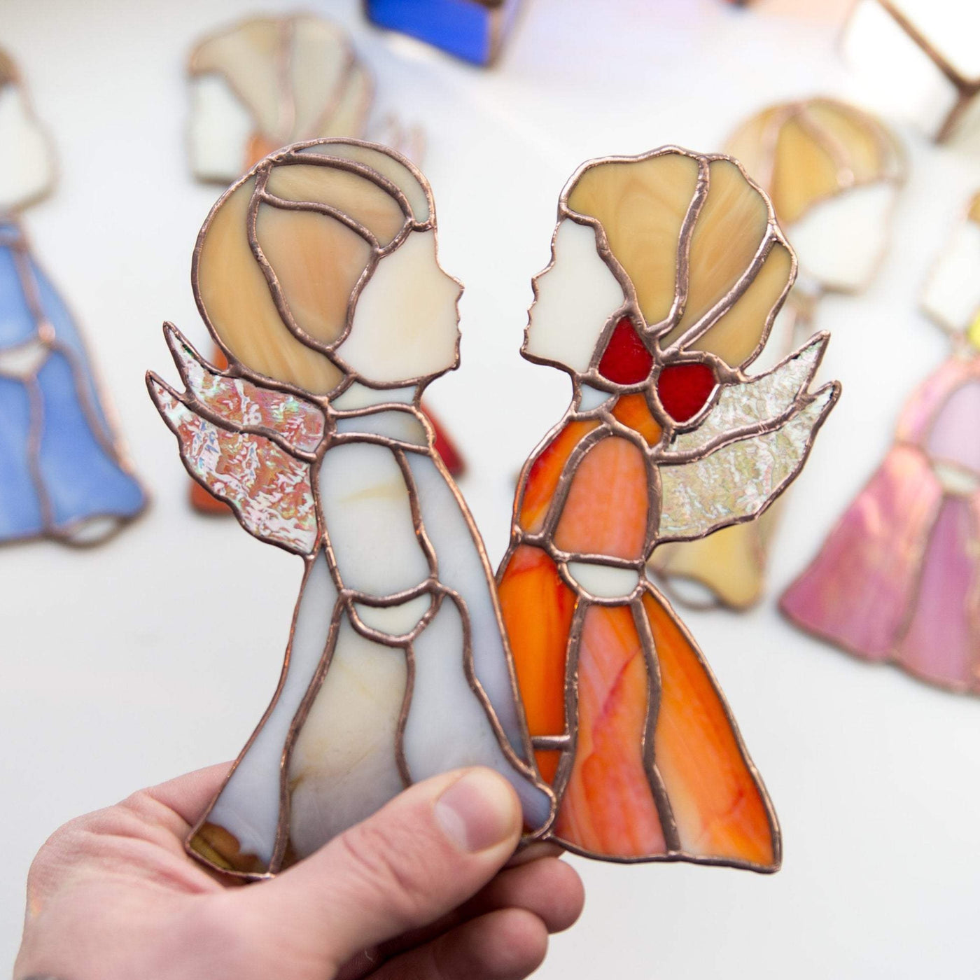 Window hangings of stained glass beige boy and red girl angels