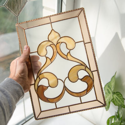 Stained glass panel with beige frame and light brown classic ornamental ringlets 