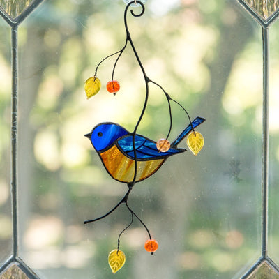 Stained glass bluebird sitting on the branch with leaves and berries suncatcher