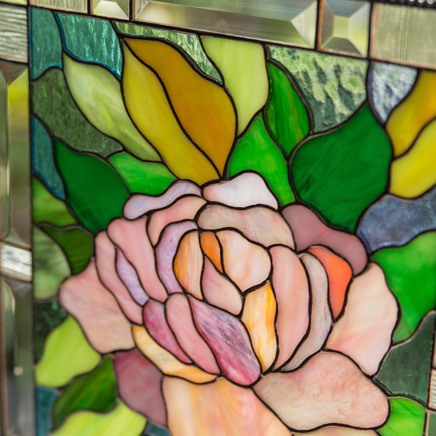 Zoomed stained glass panel depicting pink peony
