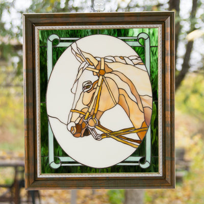Stained glass horse's head in an oval and green background around it panel in a frame