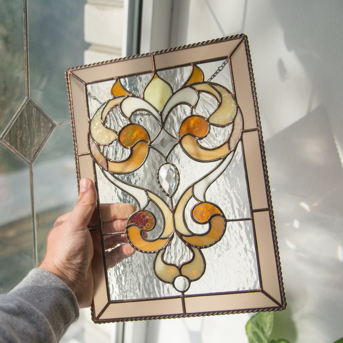 Stained glass clear panel with beige frame and fanciful ornaments